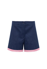 Bermuda Sophie feminina azul marinho, tecido de algodão, caimento estruturado e com barras dobradas com listras vermelhas e brancas.