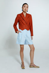 Blazer diana feminino em linho laranja, botões forrados na mesma cor em conjunto com bermuda escada em linho azul claro, cintura levemente ajustada.