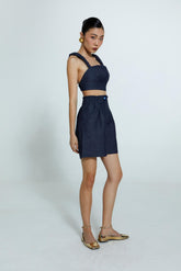 Top azul escuro em jeans com alças largas e Bermuda Escada Jeans feminina azul escuro tem caimento reto e bolsos laterais.