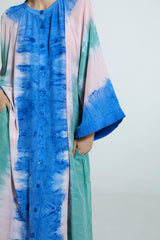 Vestido amplo de seda com padronagem tie-dye artesanal em tons vibrantes de azul, verde e rosa. Manga ampla e caimento solto.