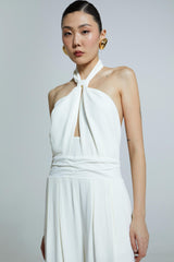 Macacão off-white com decote torcido e alças delicadas.