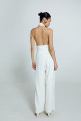 Macacão off-white com decote torcido e alças finas.