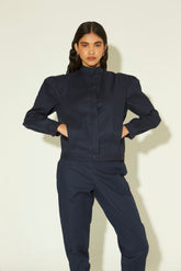 Jaqueta feminina azul marinho em algodão com gola alta, mangas volumosas e corte reto.