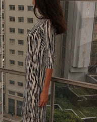 Vestido Sara com listras preto e branco, recortes estratégicos e caimento fluido.