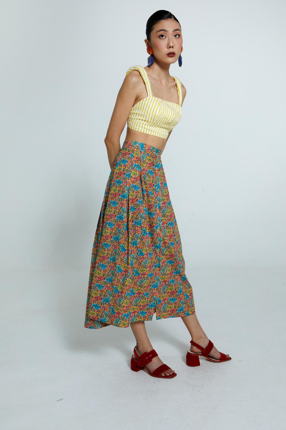 Saia floral multicolorida com cintura alta e modelagem fluida.