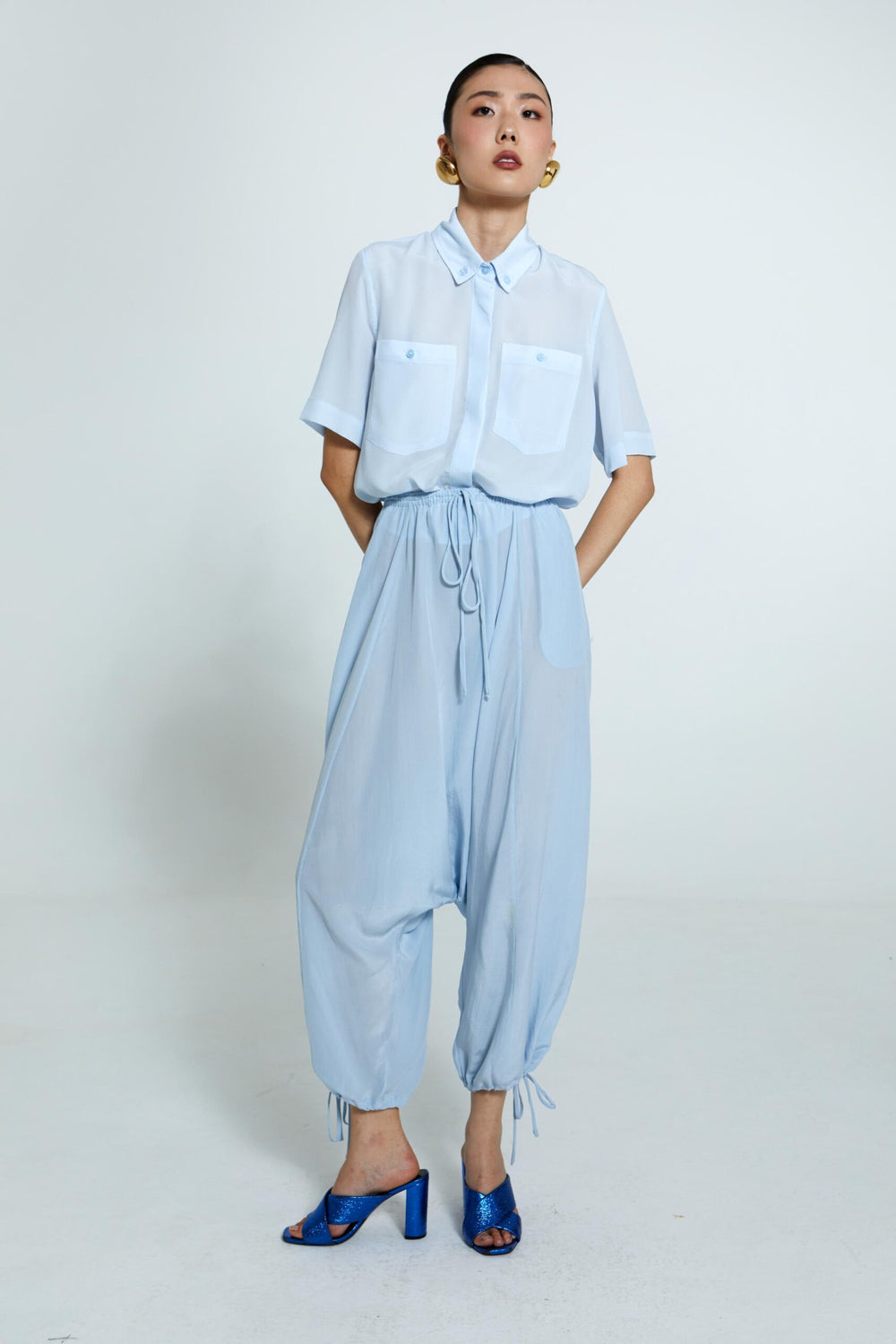 Camisa Emma feminina azul-celeste feminina com corte reto, seda fluida e bolsos frontais