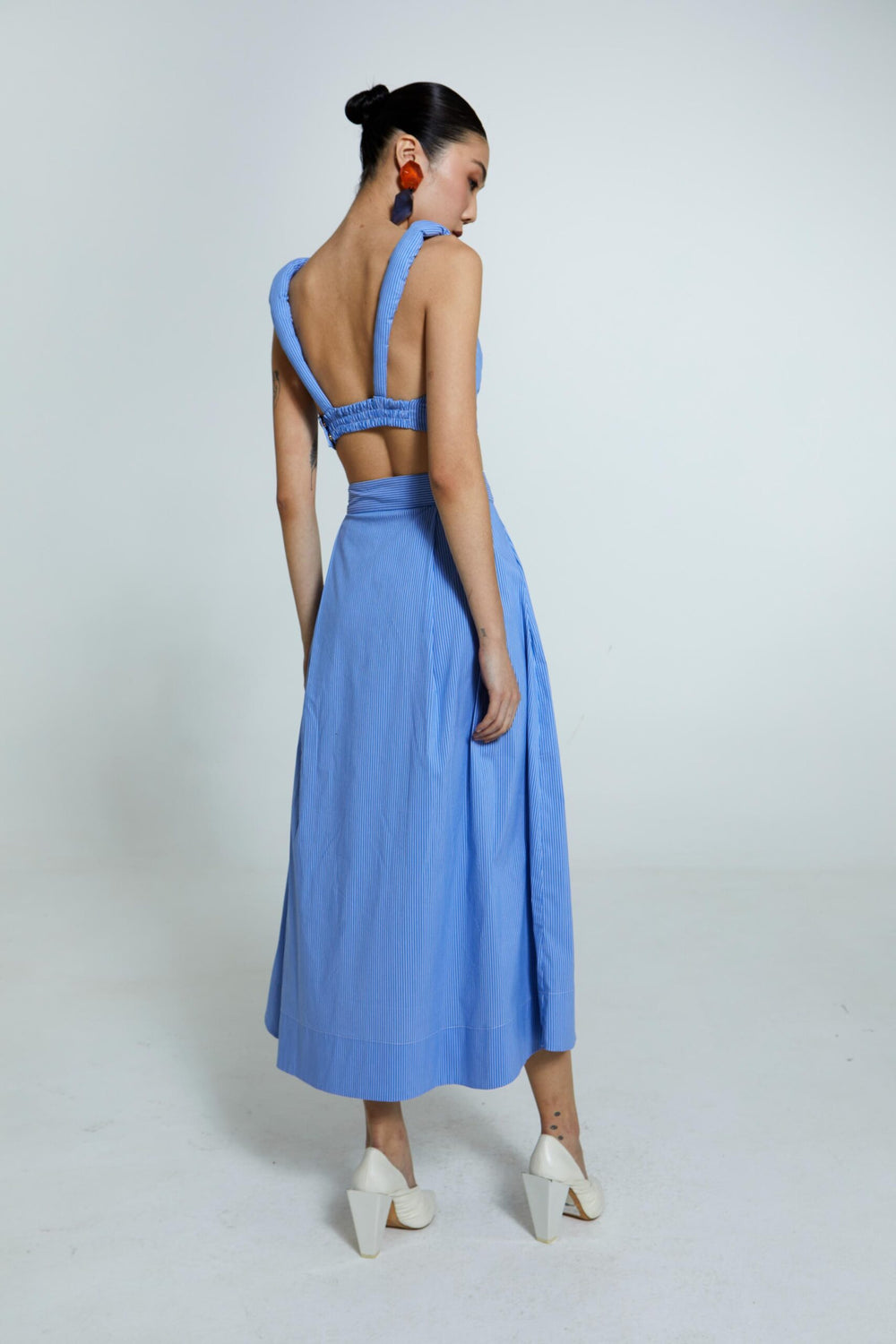 Saia midi azul com listras, cós estruturado e botões frontais.