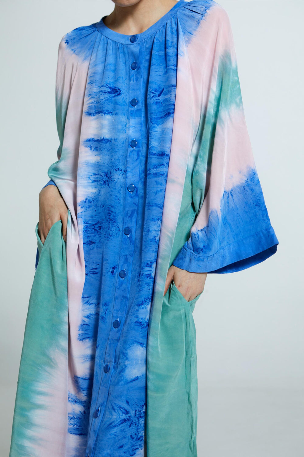 Vestido tie-dye artesanal com mangas amplas, abotoamento frontal e caimento solto.