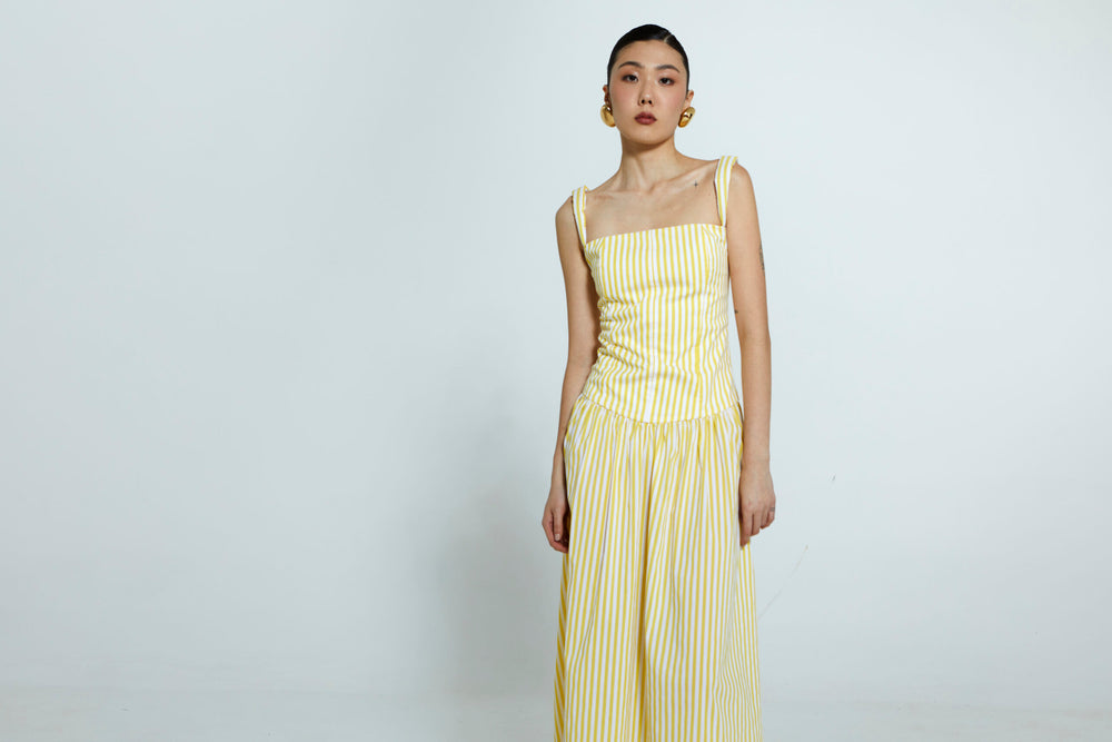 Vestido listrado amarelo e branco com cintura marcada em algodão.