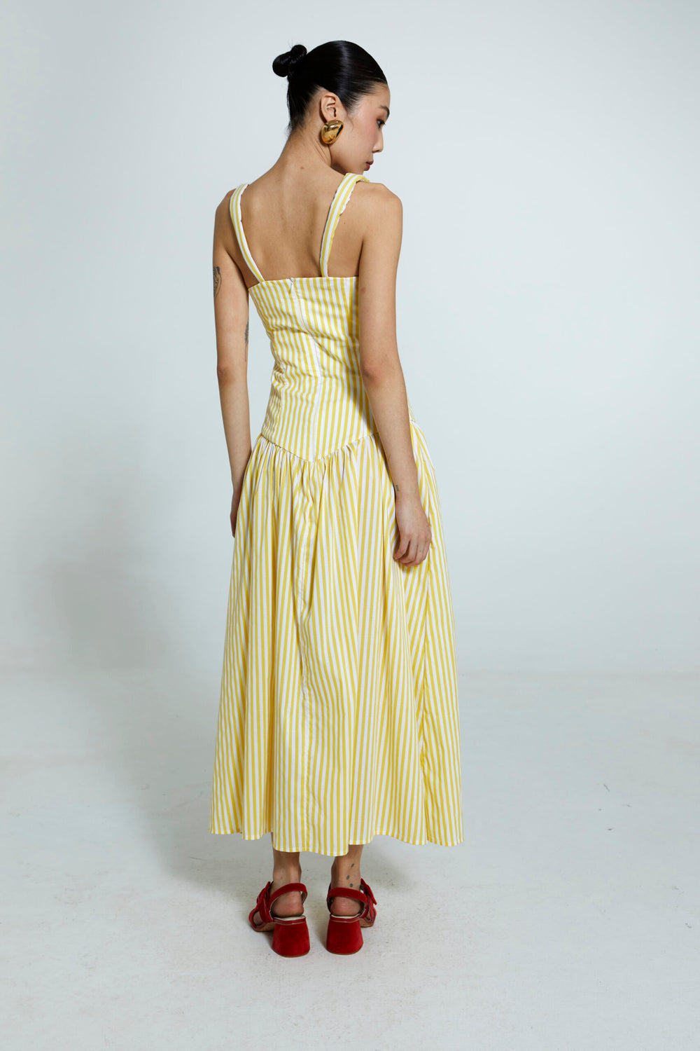 Vestido com listras amarelas e brancas, alças largas em algodão.