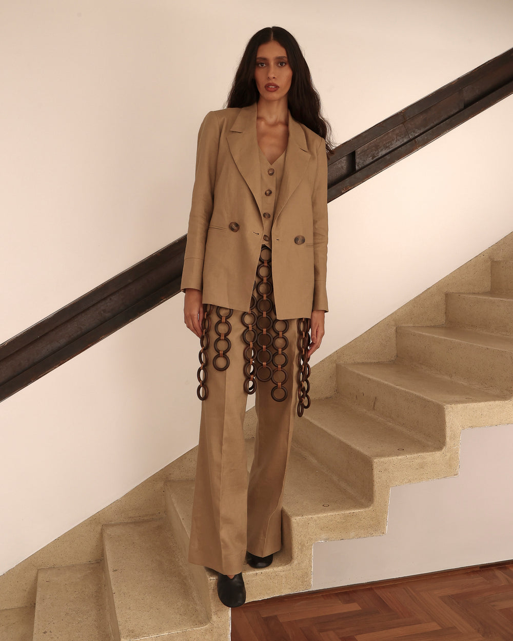 Blazer bege com corte reto, forro em algodão e botões frontais.